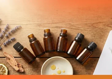 Essential oil blend chart flat-lay with six amber bottles, lavender, and cedarwood on wood surface